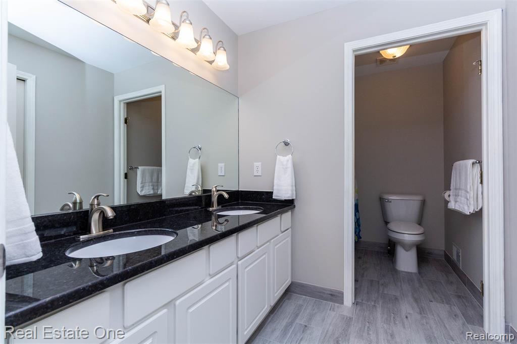Upstairs main full bath with double vanity and separate commode and shower