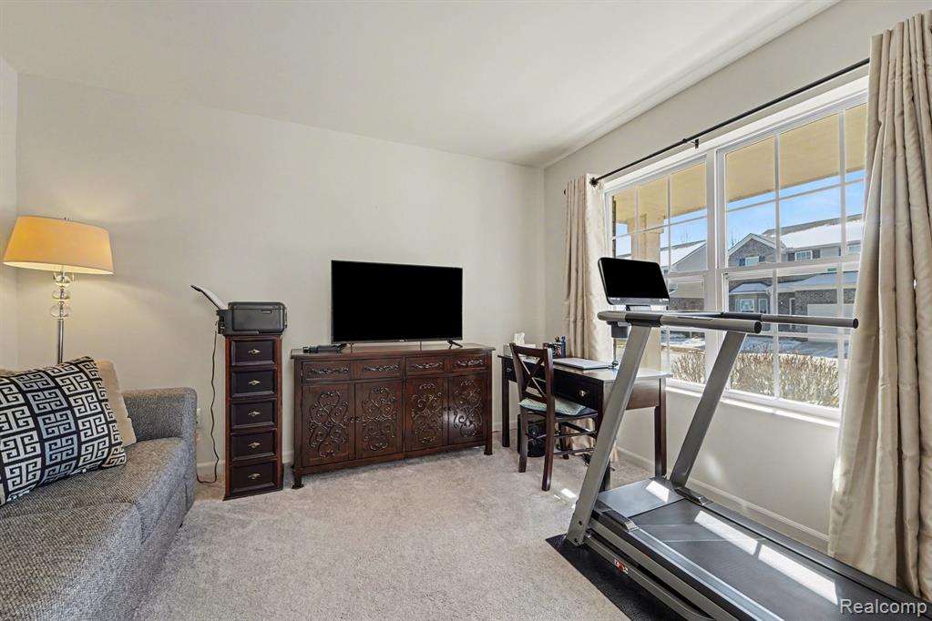 Exercise area with light colored carpet and baseboards