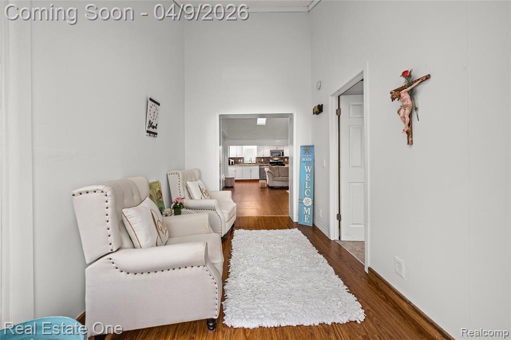 Sitting room with a high ceiling and wood finished floors