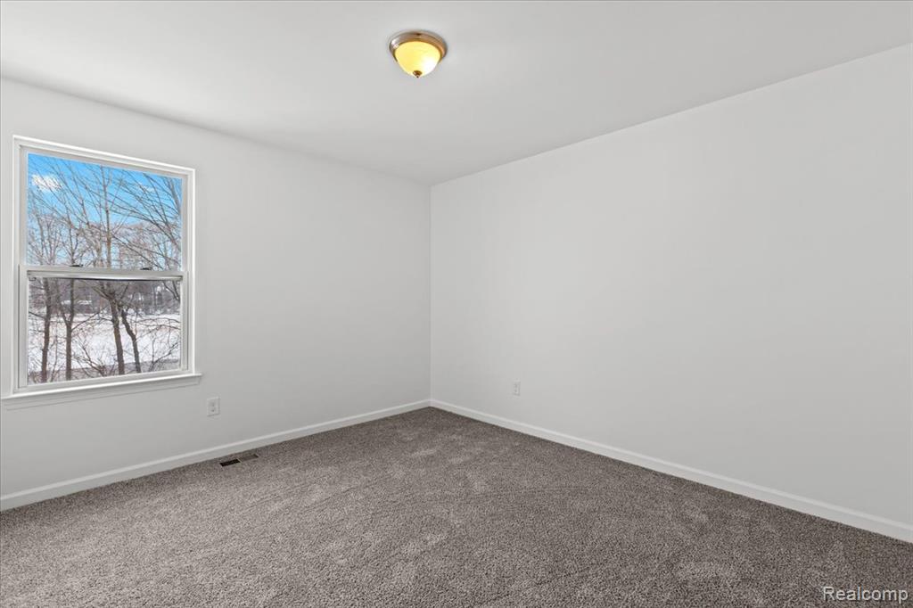 Finished basement with dark wood-type flooring and baseboards