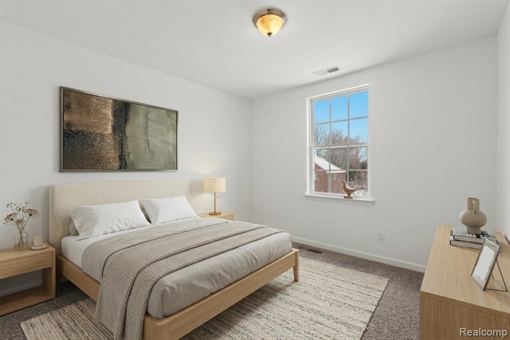 Kitchen featuring stainless steel fridge, light wood-style flooring, a warm lit fireplace, hanging light fixtures, and a kitchen island