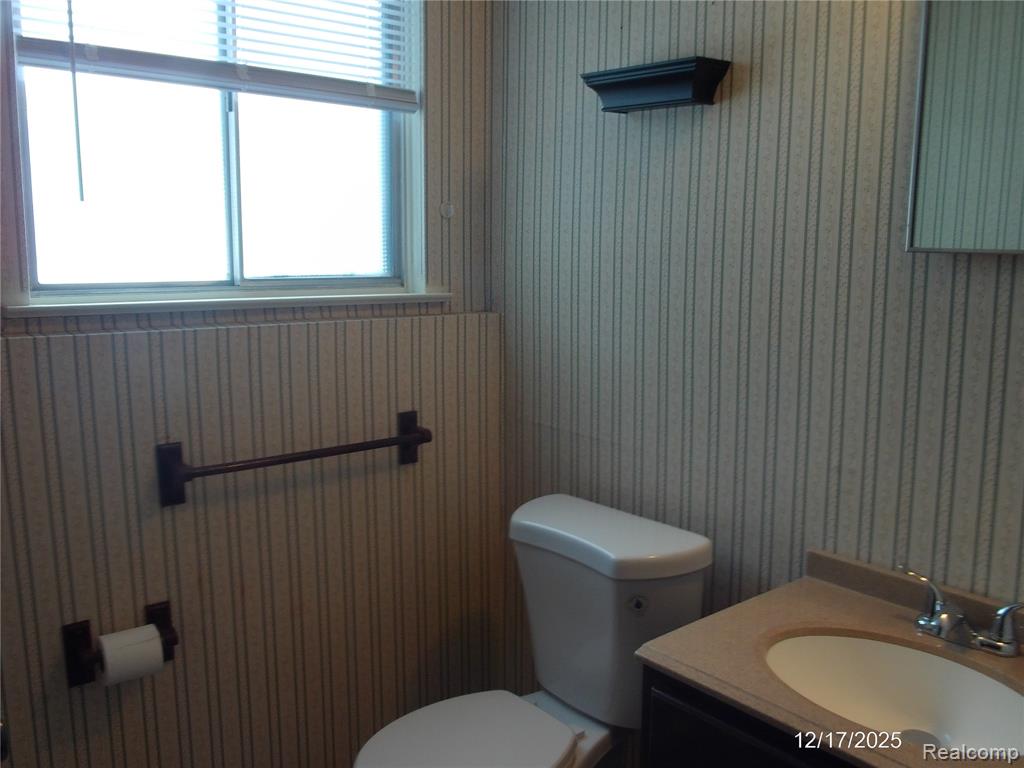 Unfurnished living room with dark wood finished floors, a brick fireplace, and a ceiling fan