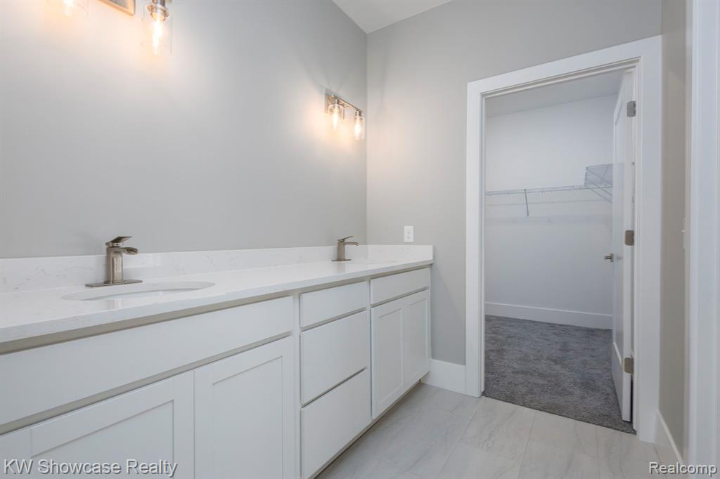 Primary Bath featuring double vanity and a walk in closet