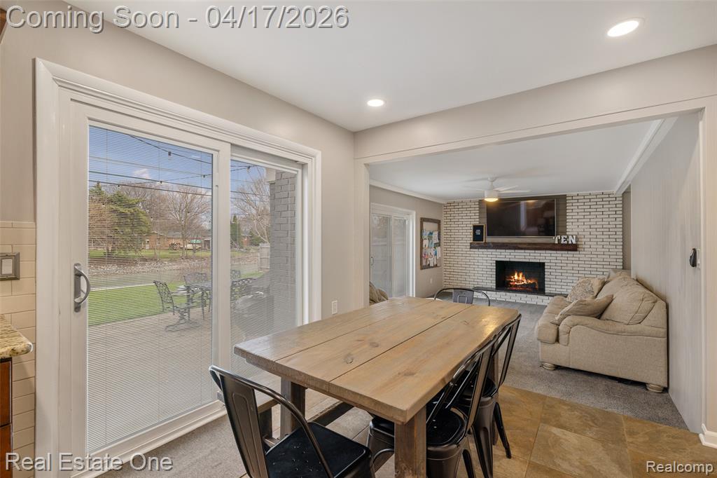 Dining space with light carpet, a fireplace, recessed lighting, and a ceiling fan