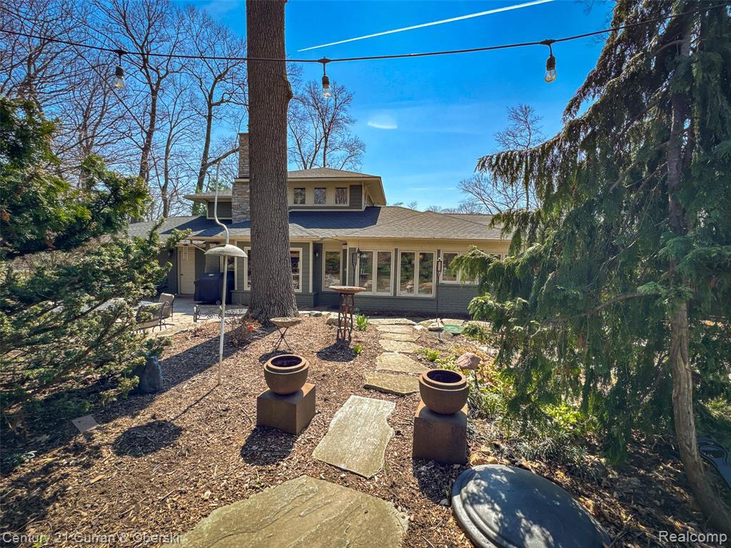 Back of house with a patio area and a shingled roof