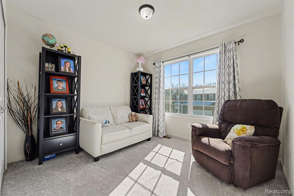 Living area with light carpet and baseboards