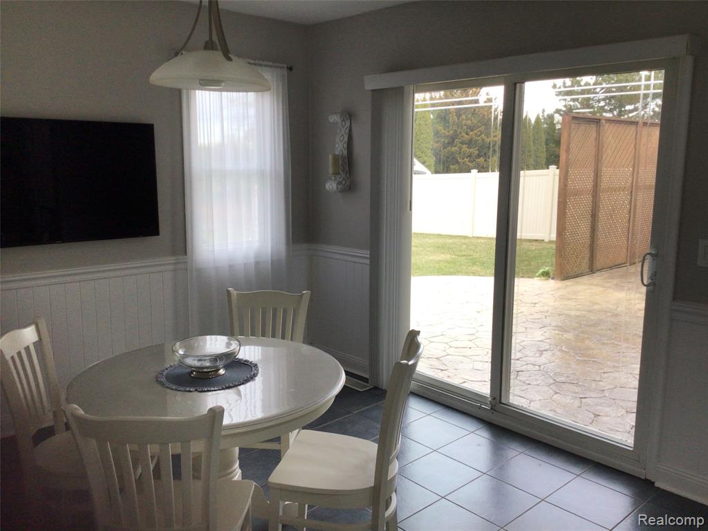 Tiled dining space with a wainscoted wall