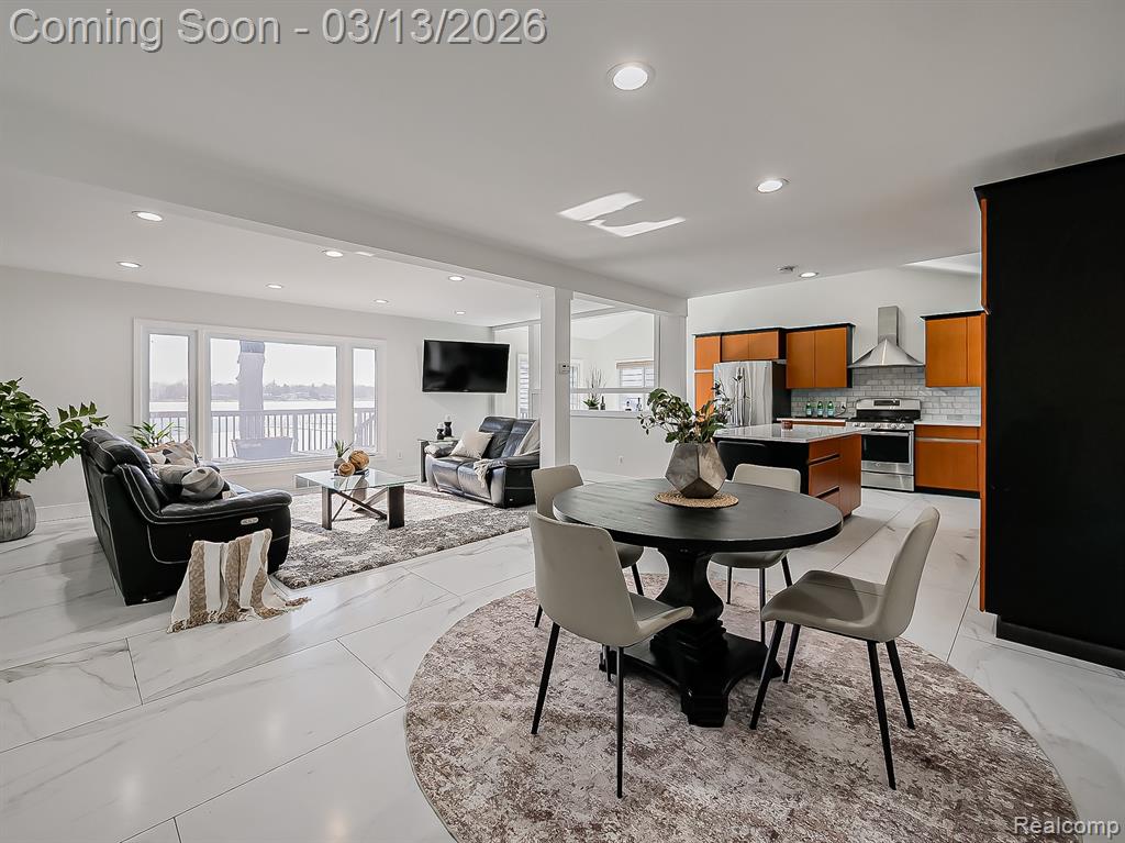 Dining area featuring recessed lighting and light marble finish floors