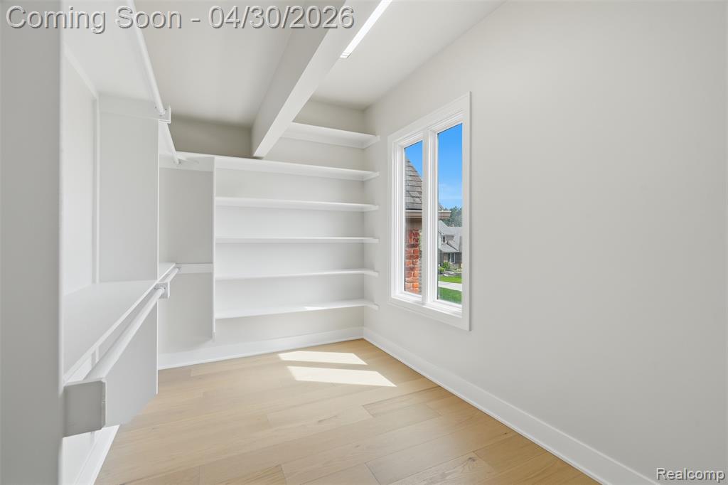 Primary Bedroom Walk in closet with wood flooring