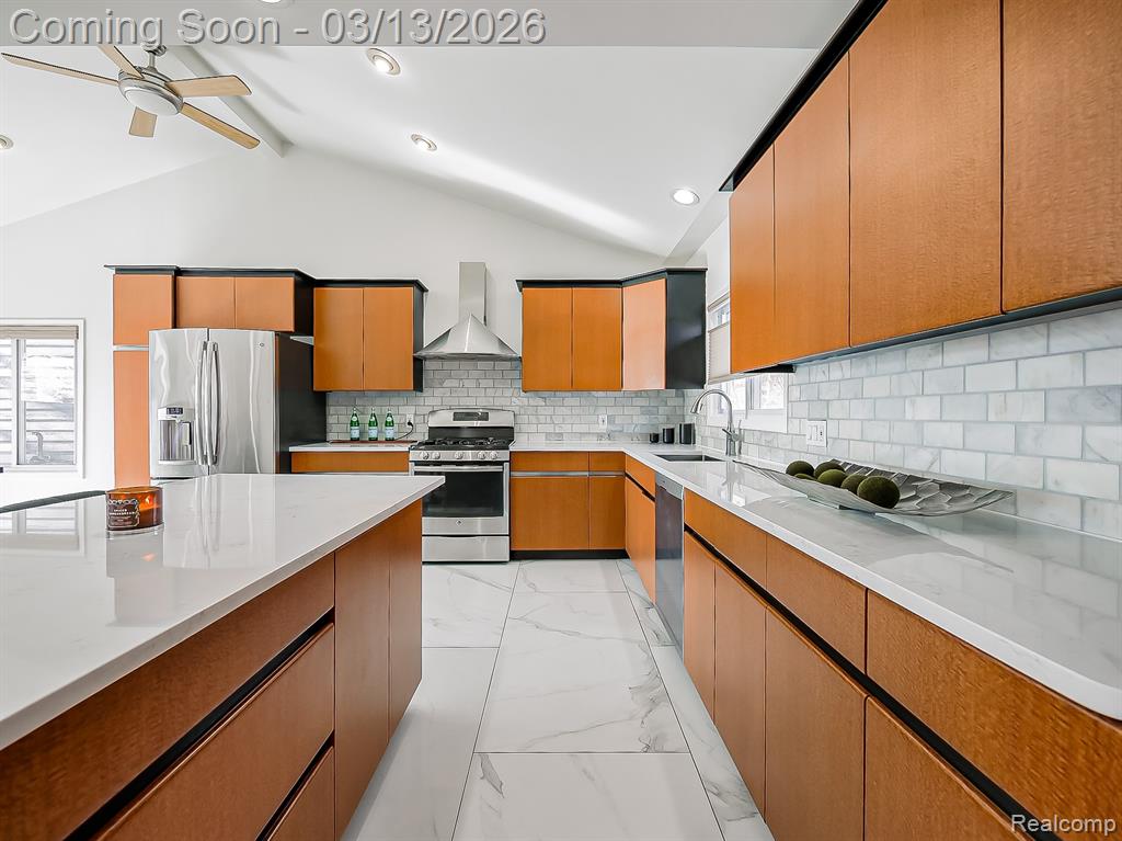 Kitchen featuring stainless steel appliances, a kitchen island, backsplash, vaulted ceiling, and a breakfast bar