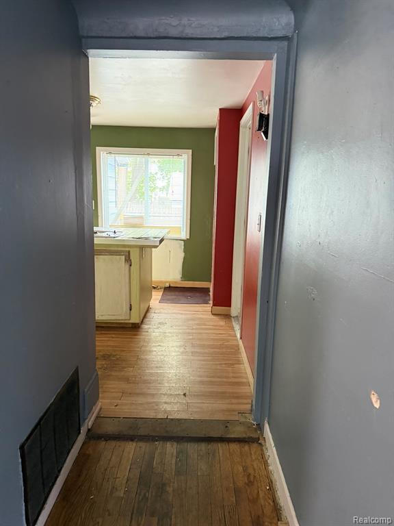 Hall featuring dark wood finished floors and baseboards