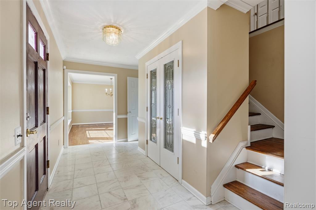 Unfurnished dining area with suspended lighting, light wood-style flooring, and ornamental molding