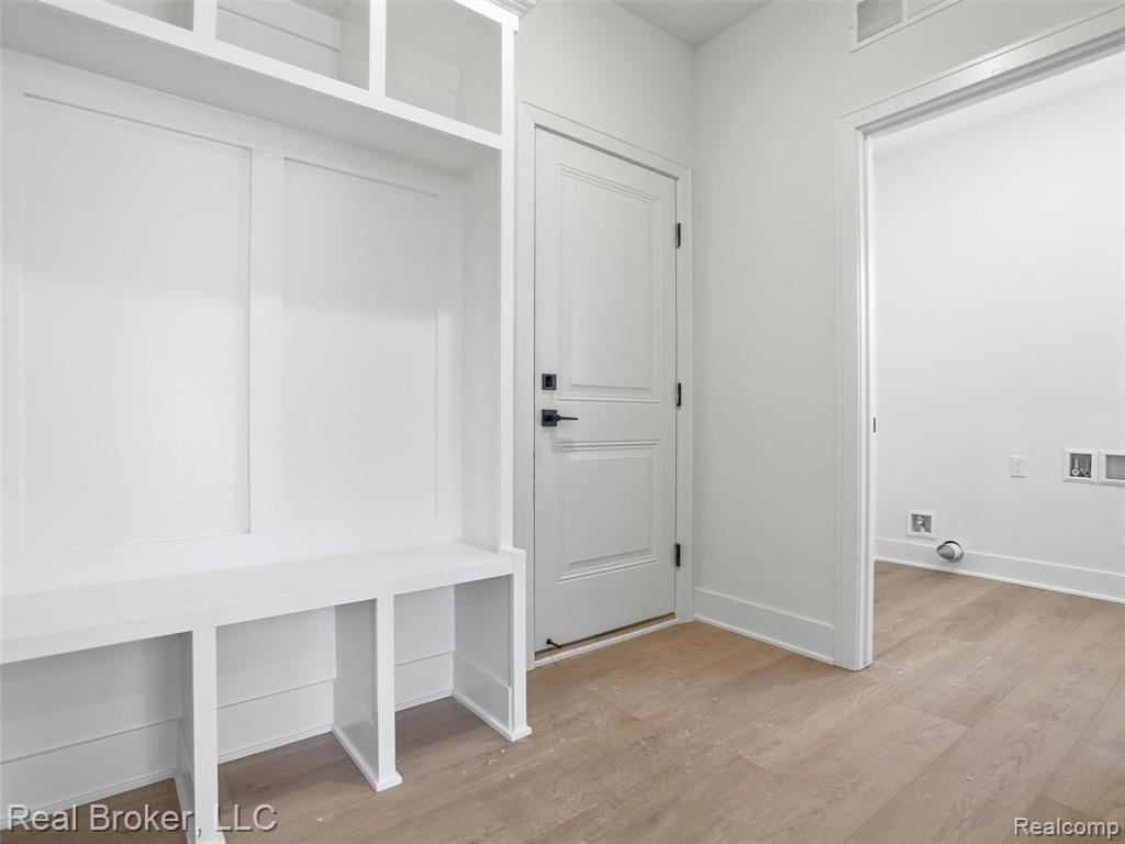 Mudroom with light wood-style floors and baseboards