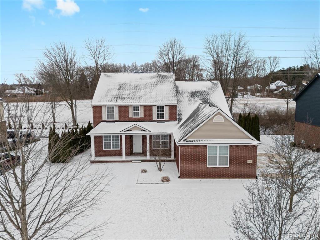 View of front of property with brick siding and covered porch