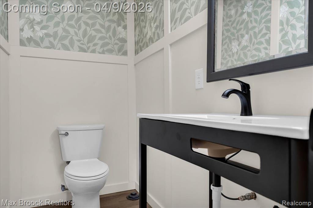 Bathroom featuring vanity, dark wood-style flooring, and wallpapered walls