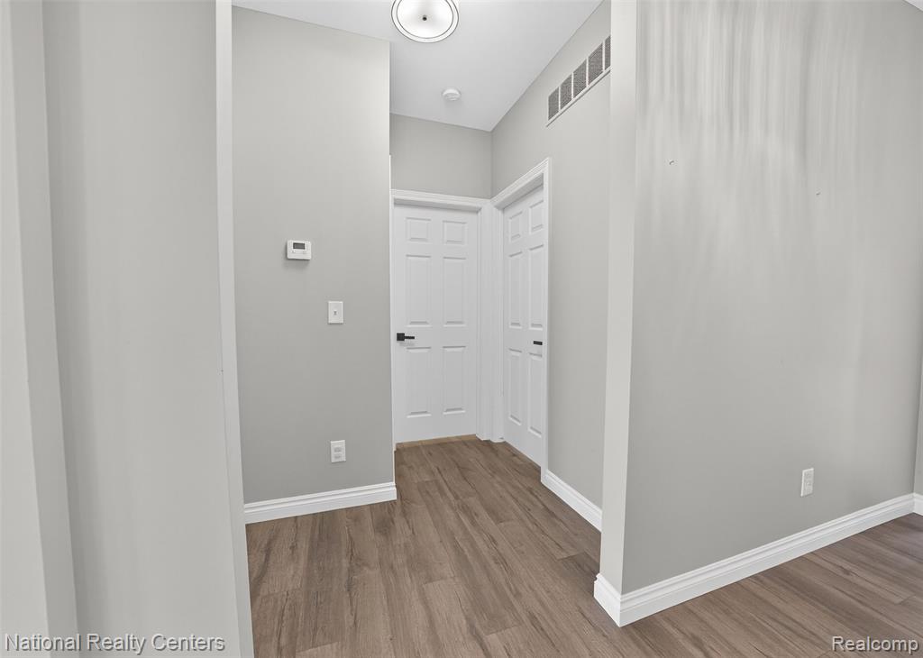 Corridor with baseboards and wood finished floors