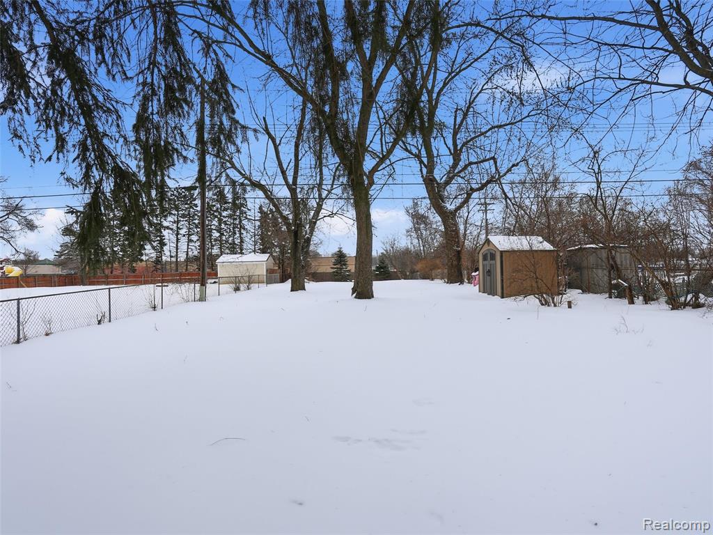 Snowy yard with a storage shed