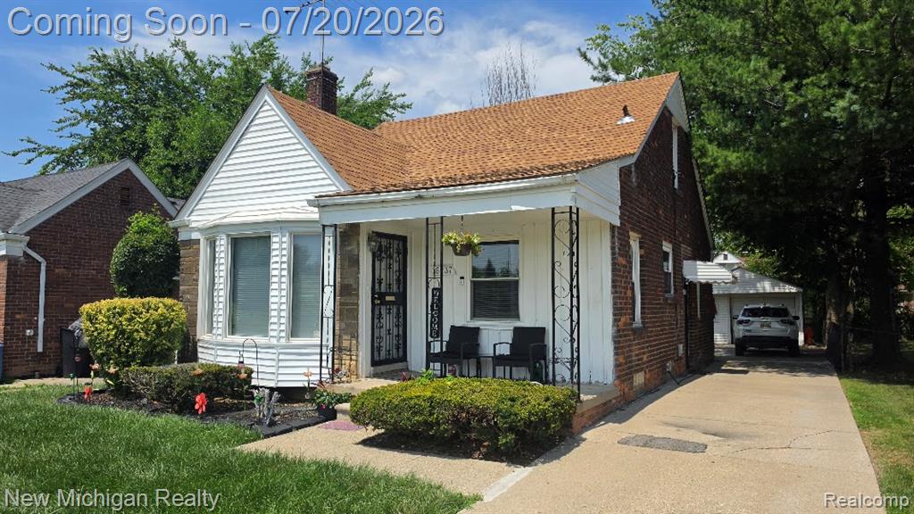 Brick and siding home featuring a front porch, bay window, and a gabled roof