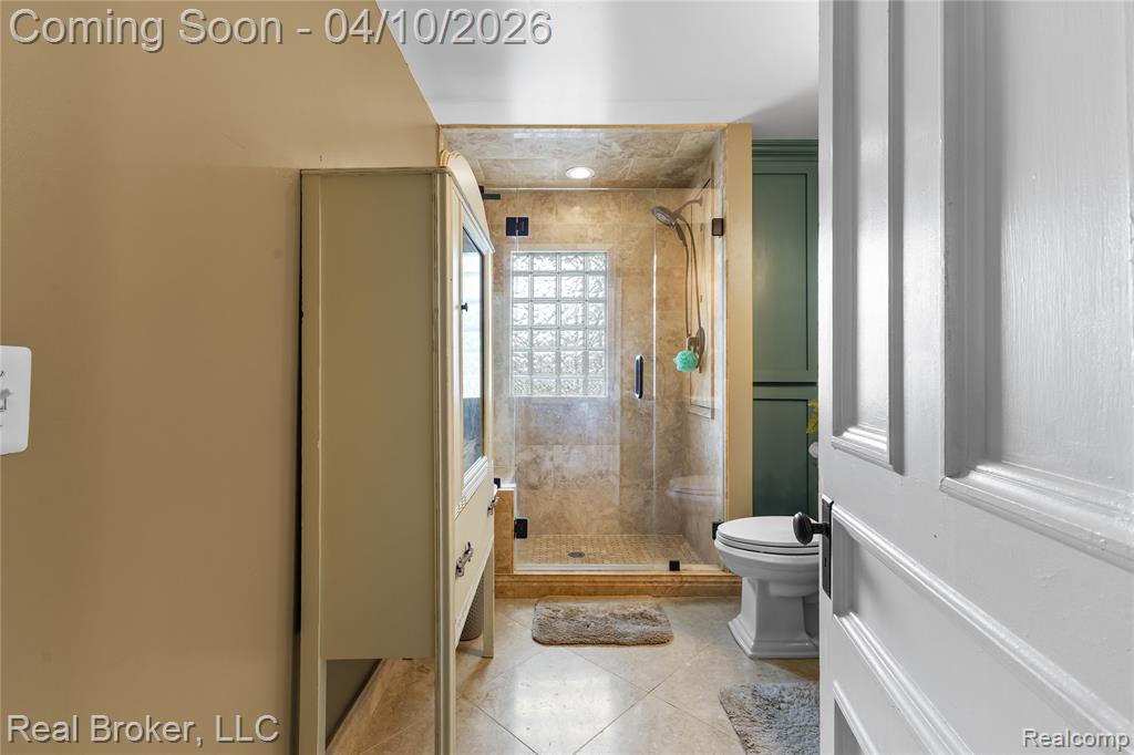 Full bathroom with a shower stall, light tile patterned floors, and vanity