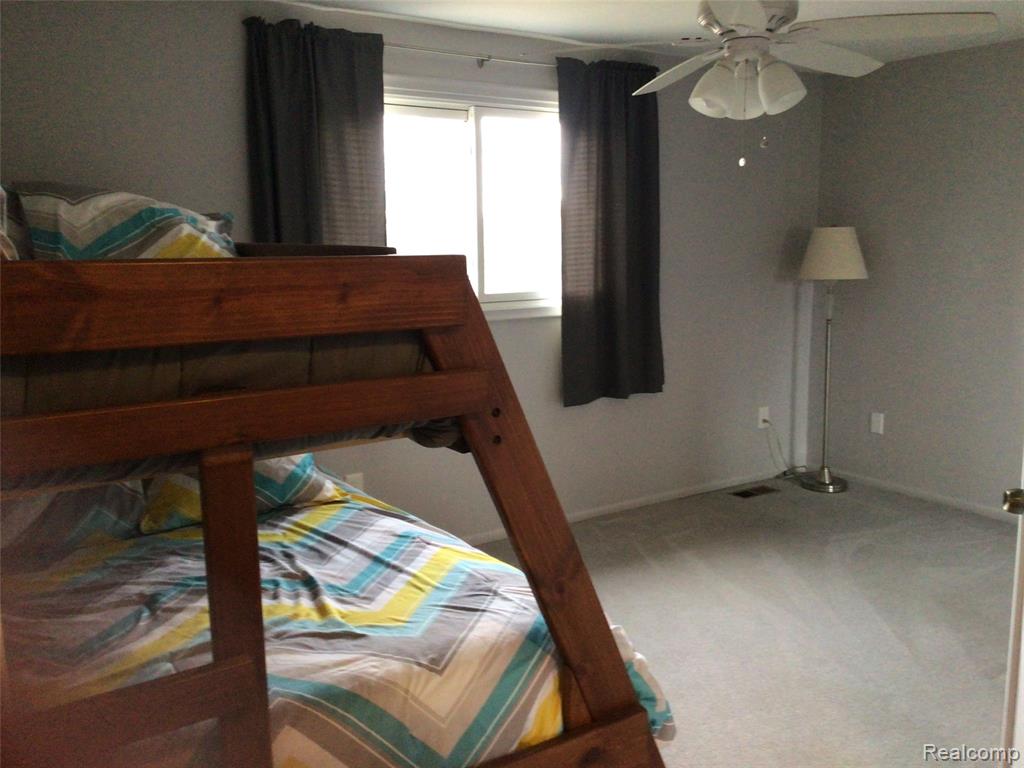 Bedroom featuring light colored carpet and ceiling fan