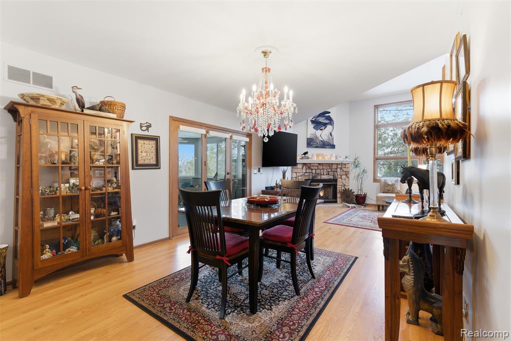 Dining room featuring hanging lights, light wood-style floors, and a fireplace
