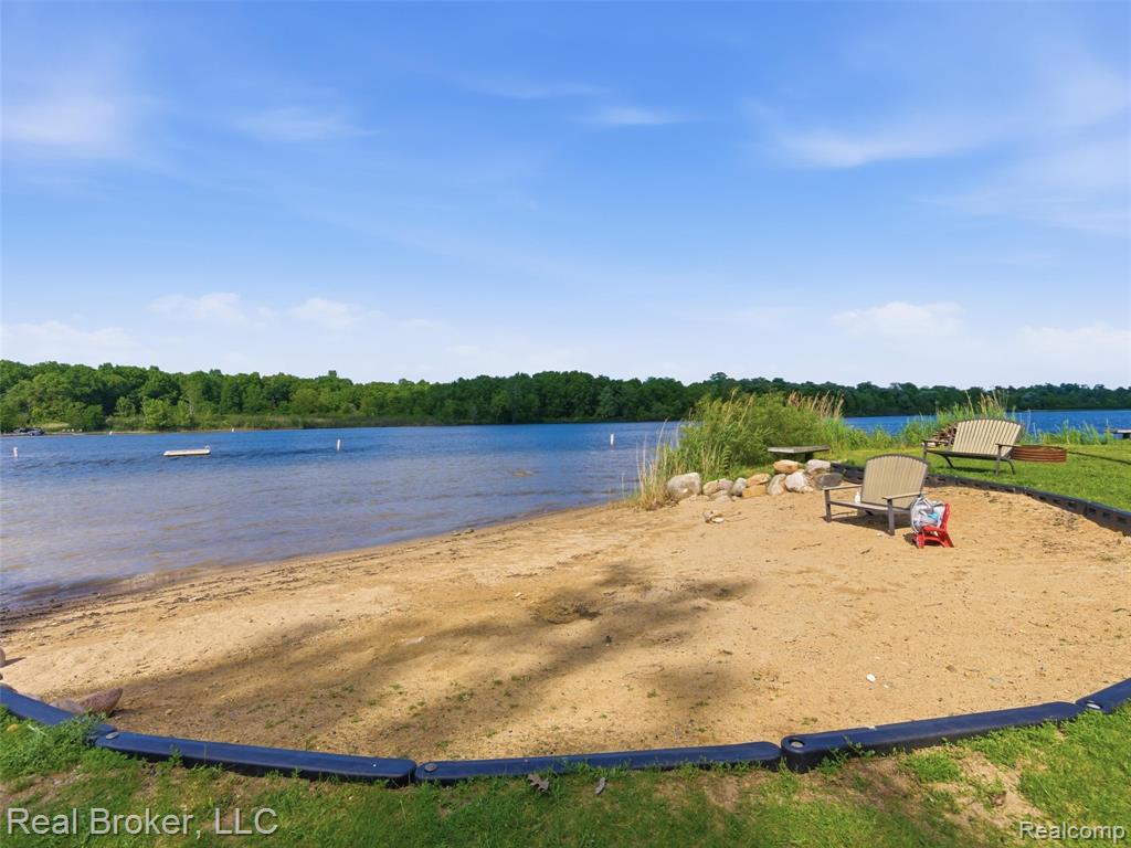 Waterfront recreation area featuring a multi-component playground with a red slide, monkey bars, and a swing set
