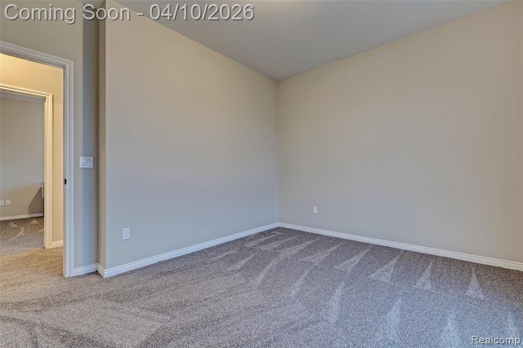 Unfurnished room with light colored carpet and baseboards