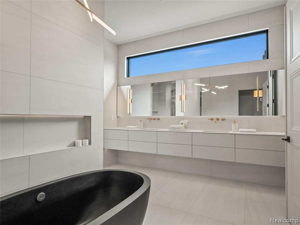 Full bathroom with double vanity, a soaking tub, and light tile patterned flooring