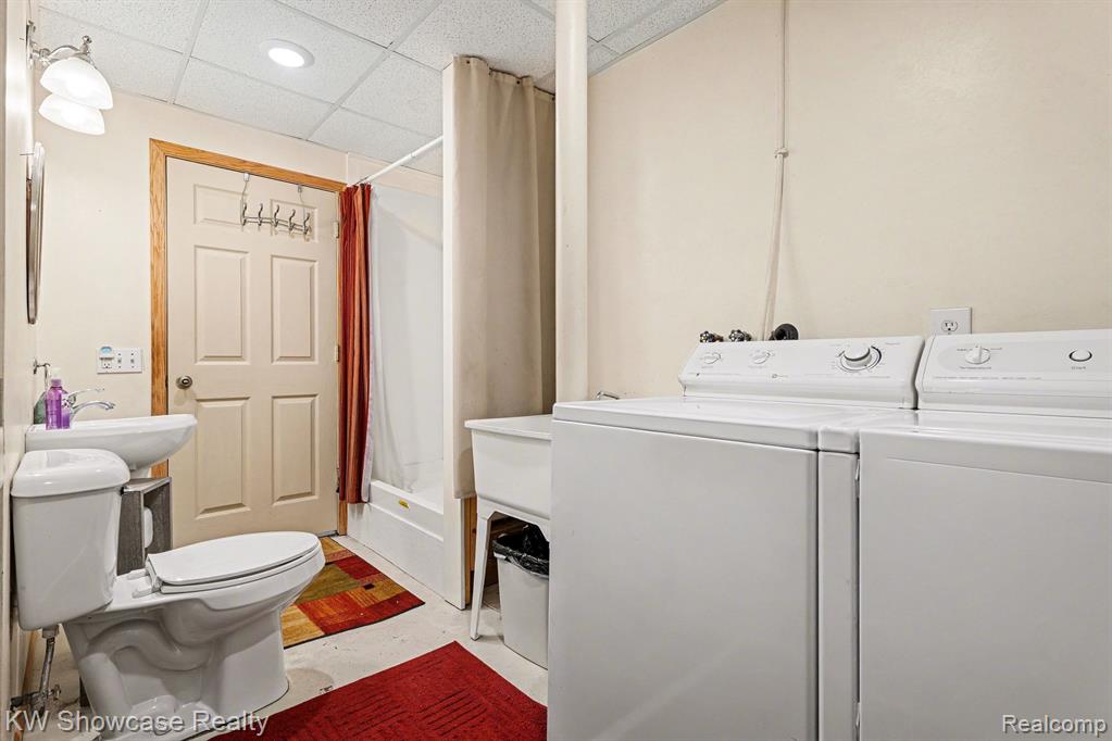 Laundry area featuring a drop ceiling, concrete flooring, and separate washer and dryer