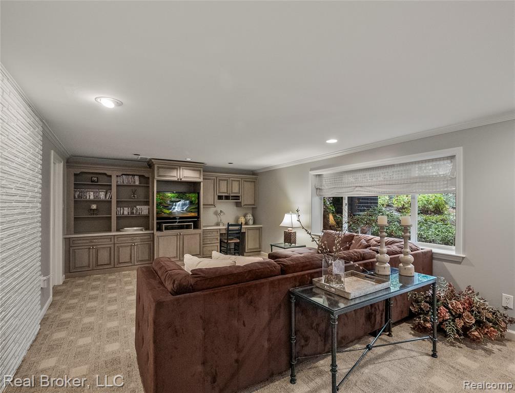 Recreation room with carpet floors, recessed lighting, a brick fireplace, and crown molding