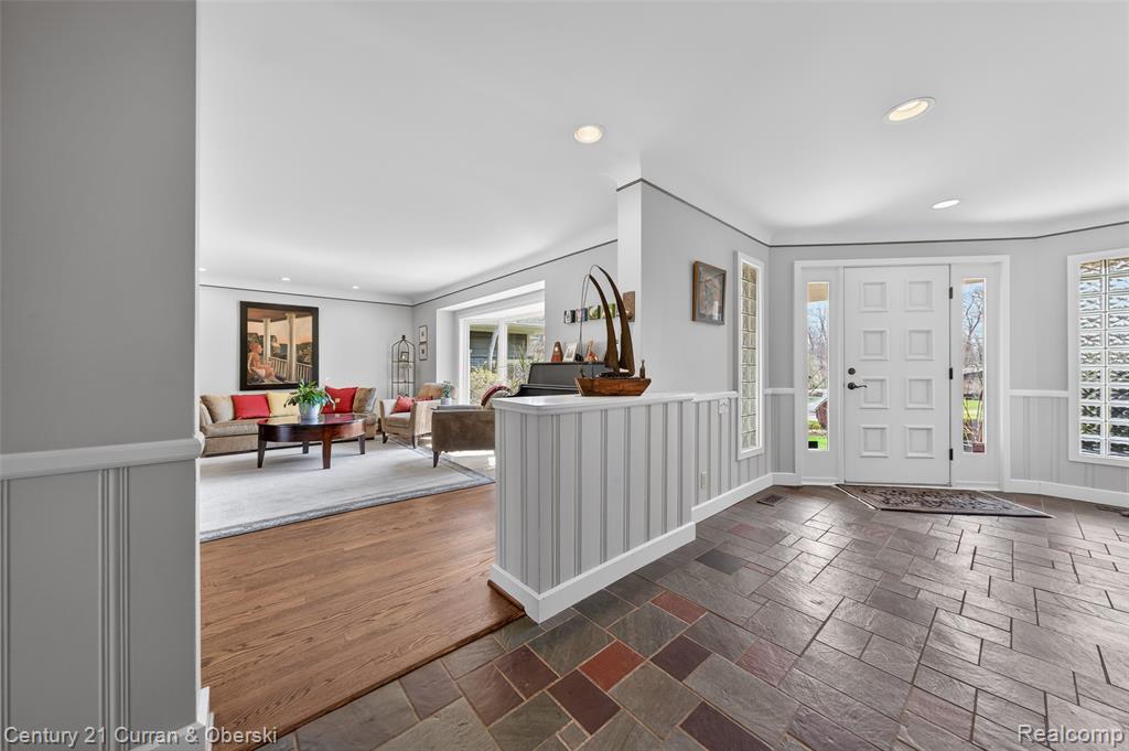 Foyer entrance with stone tile flooring and recessed lighting