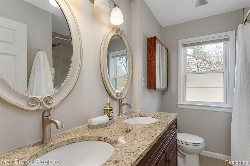 Full bath featuring double vanity and a shower with curtain