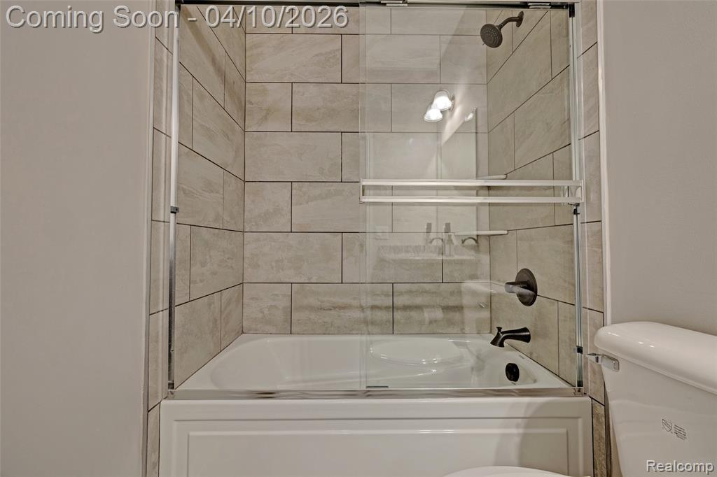 Full bath featuring toilet and enclosed tub / shower combo