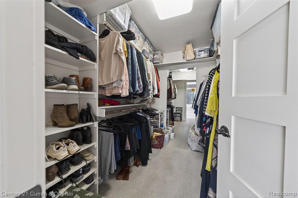 Walk in closet featuring light colored carpet