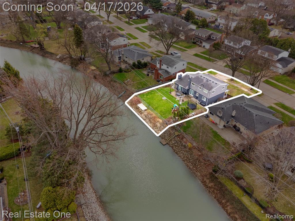 Aerial view of residential area featuring a nearby body of water