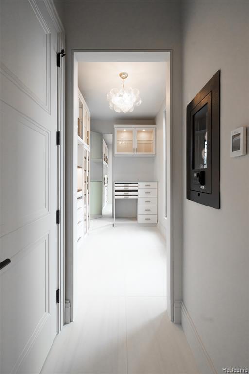 Hall featuring a chandelier and baseboards