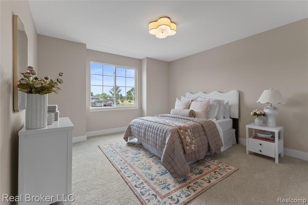 Bedroom with a raised ceiling, light carpet, recessed lighting, and a spacious closet