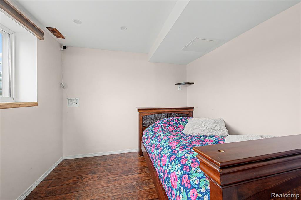 Bedroom with dark wood-type flooring and baseboards