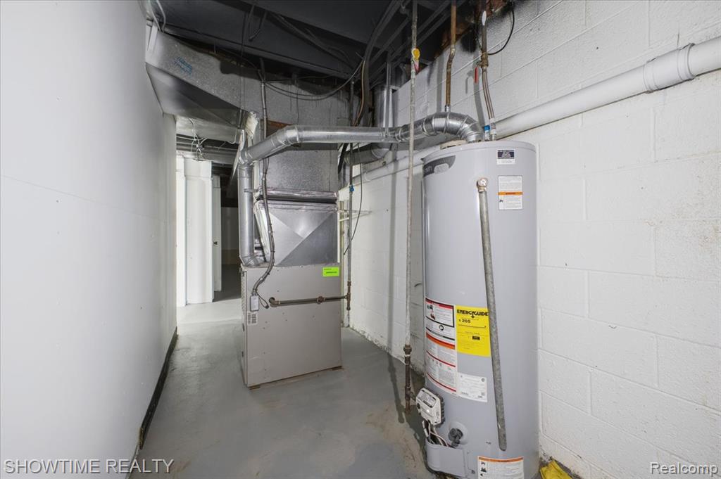 Utility room featuring water heater and heating unit