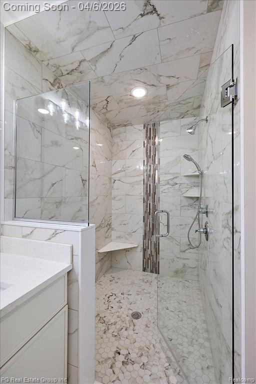 Full bath featuring vanity and a marble finish shower