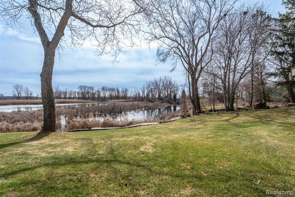 View of grassy yard with a water view