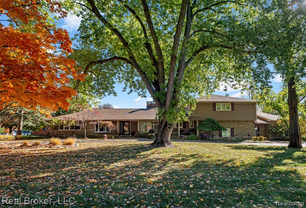 Rear view of property with a patio, a pool with connected hot tub, and brick siding
