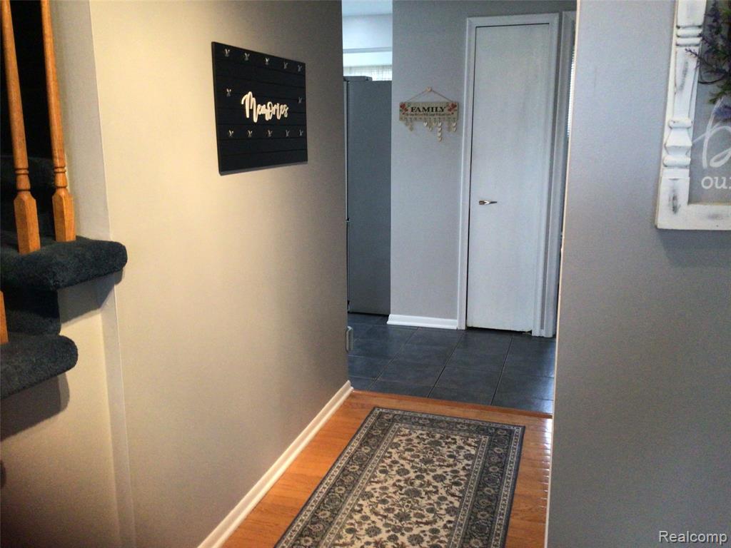 Corridor featuring baseboards and dark wood-style floors