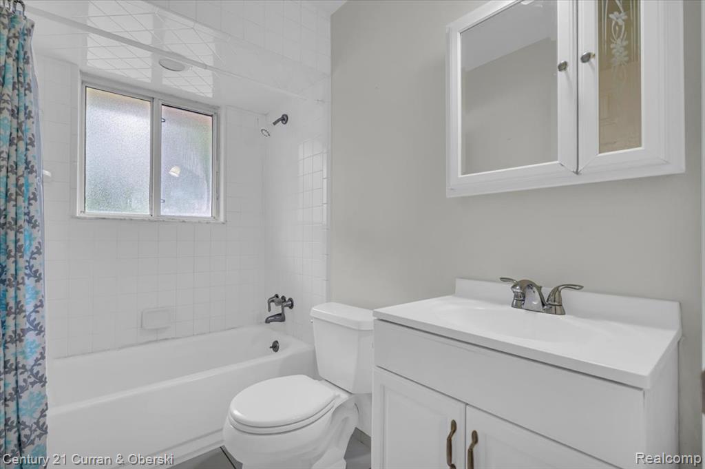 Full bath featuring shower / bath combo with shower curtain and vanity