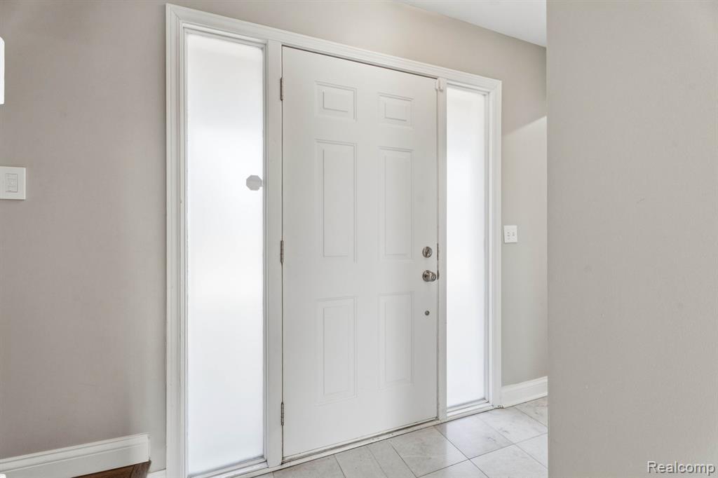 Foyer featuring baseboards and light tile patterned floors