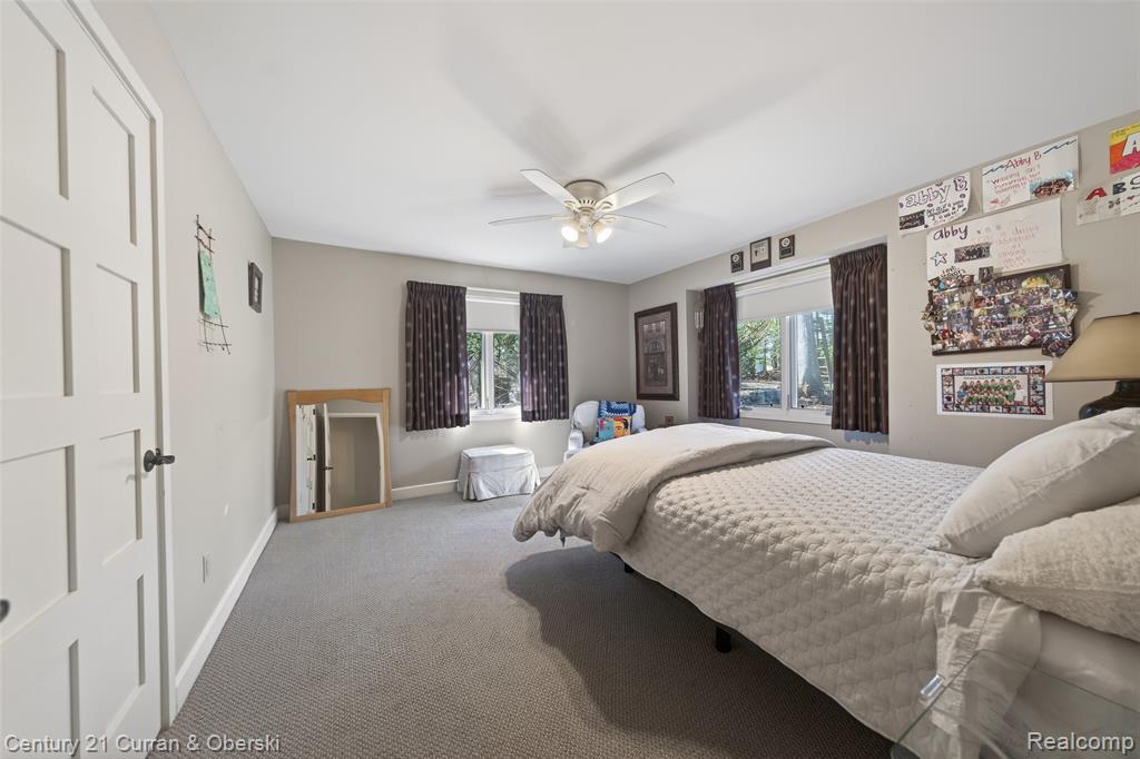 Bedroom featuring carpet floors, ceiling fan, and multiple windows
