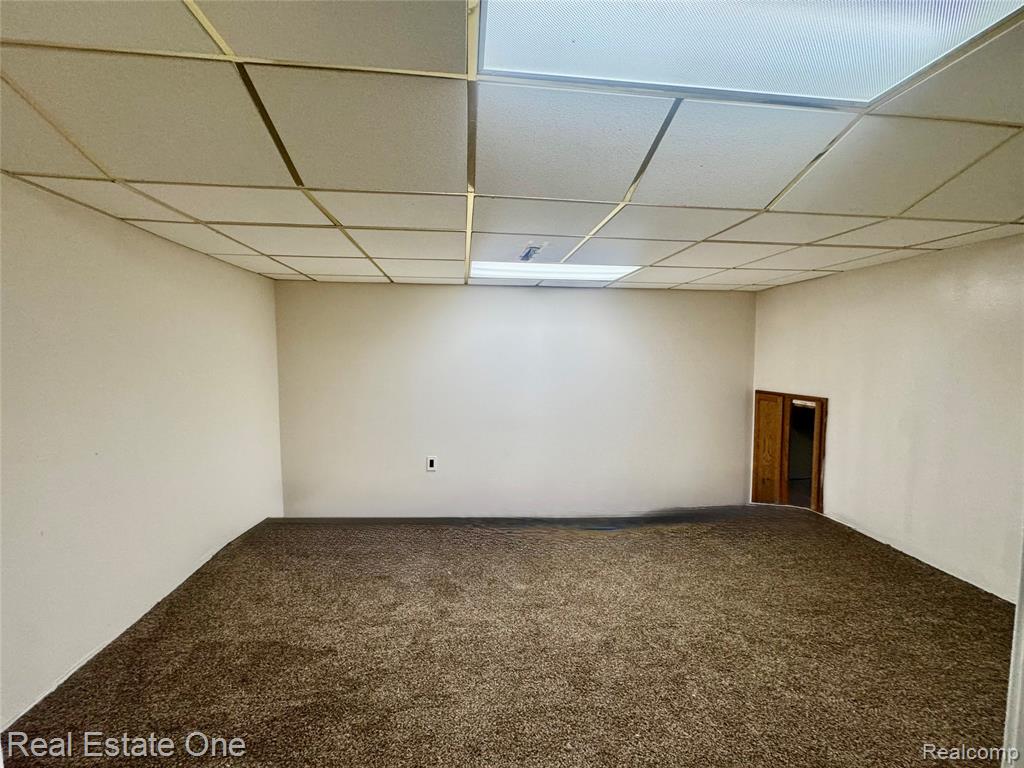 Carpeted spare room with a drop ceiling