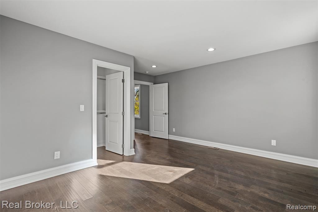 Unfurnished bedroom featuring recessed lighting, dark wood-type flooring, and a closet