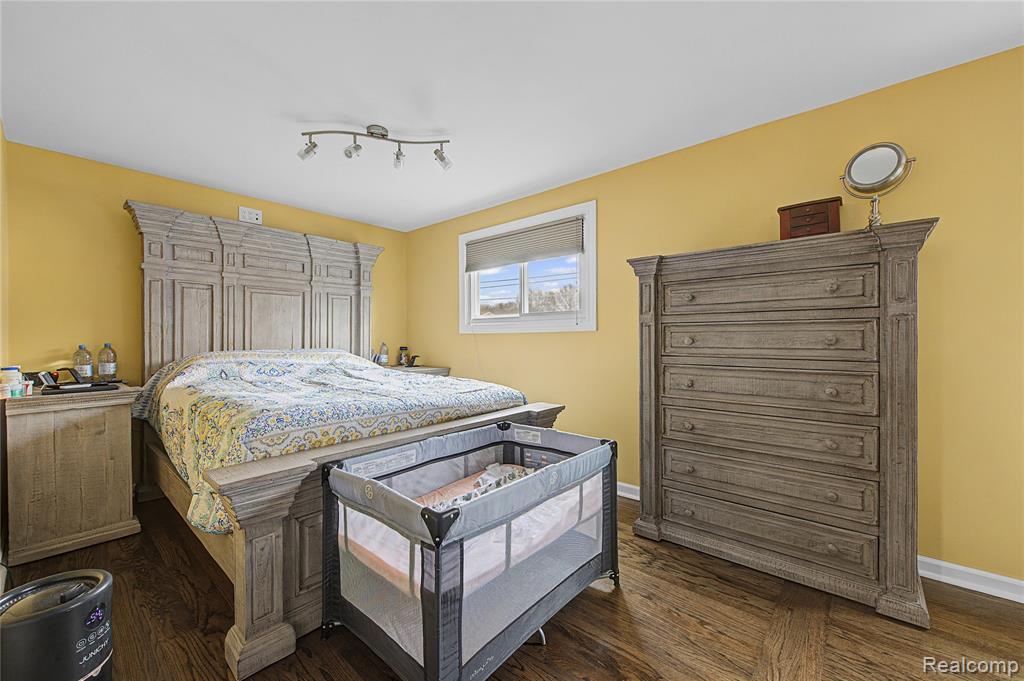 Bedroom featuring dark wood-style flooring and baseboards