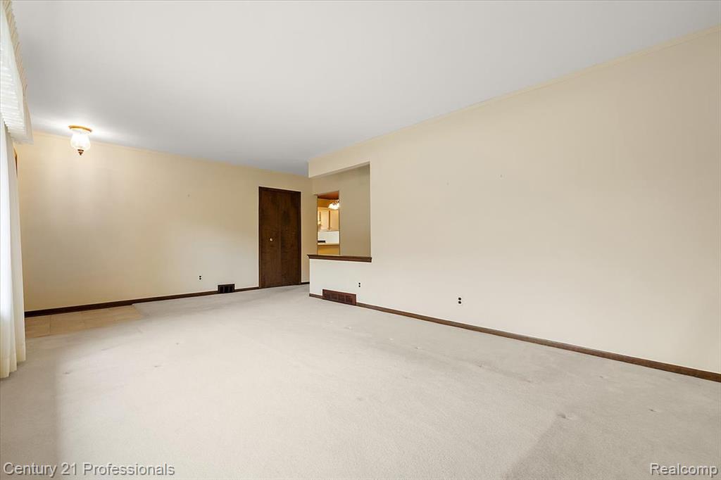 Spare room featuring carpet floors and baseboards